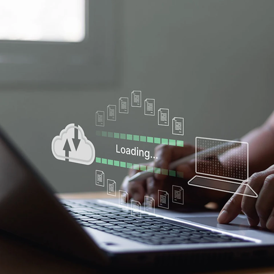 eine Grafik schwebt über einen Laptop, der aufgeklappt ist, Daten fliegen aus der Cloud zu einem Laptop, Hände und Arme von einem Mann sind zu sehen